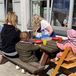 Børn og voksne spiser udendørs